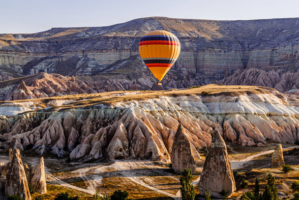 Goreme / Nevsehir, Туреччина - 27 вересня 2019: Кольорові повітряні кулі, що пролітають над долиною в Каппадокії, Анатолія, Туреччина. Вулканічні гори в національному парку Ґореме.. - Фото, зображення