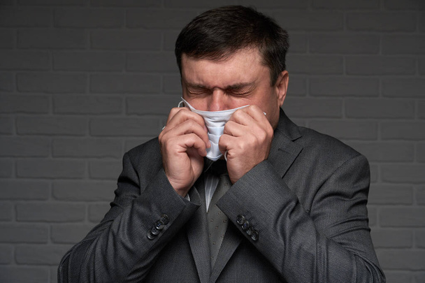 hombre infectado estornuda o tose y tiene síntomas de la enfermedad - concepto de salud y medicina
 - Foto, Imagen