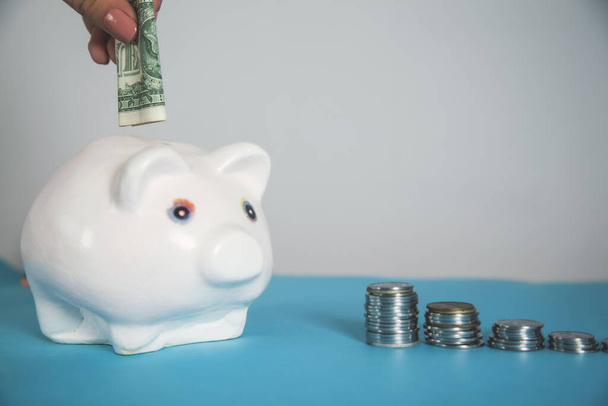 woman hand money on piggy bank  on desk - Фото, изображение