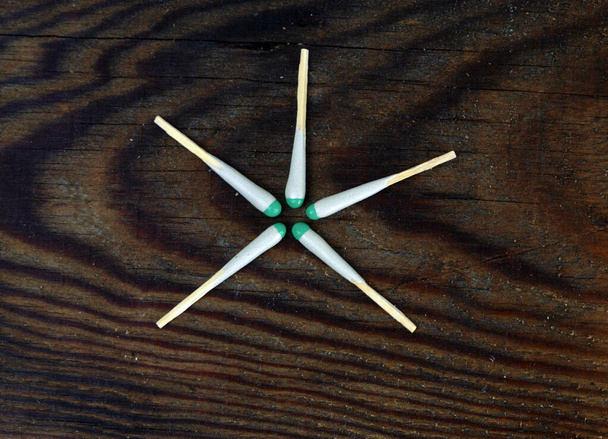 zapałki myśliwskie rozłożone przez gwiazdę leżą na drewnianym tle - Zdjęcie, obraz
