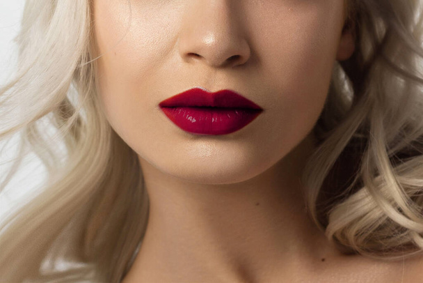 Sexual full lips. Pink gloss of lips and woman's skin. The mouth is closed. Increase in lips, cosmetology. red lipstick. Open mouth and with teeth. blonde hair. - Photo, Image