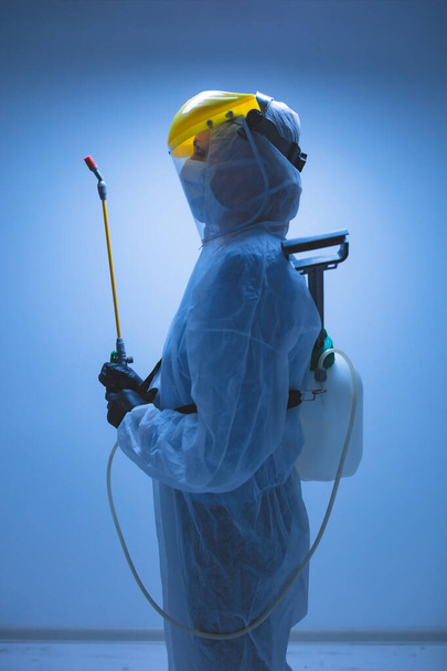 Scientifique tenant un pulvérisateur chimique pour la stérilisation et la décontamination de virus, germes, ravageurs, maladies infectieuses
. - Photo, image