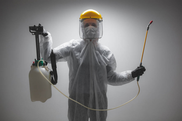 Scientist holding chemical sprayer for sterilization and decontamination of viruses, germs, pests, infectious diseases. - Photo, Image