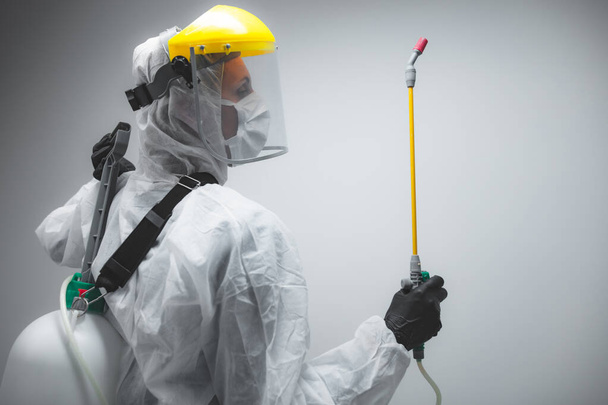 Scientist holding chemical sprayer for sterilization and decontamination of viruses, germs, pests, infectious diseases. - Photo, Image