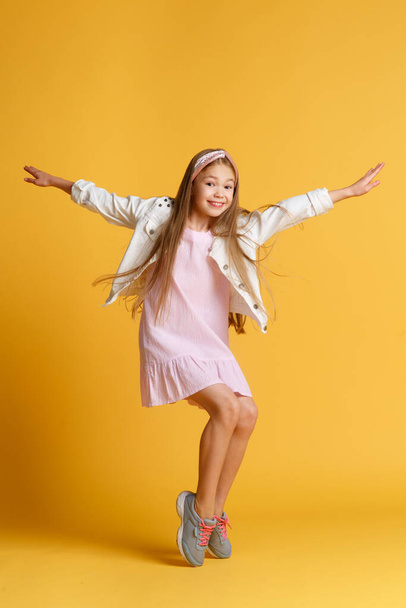 Jump of happiness. small girl jump yellow background. full of energy. Active girl feel freedom. Fun and relax. feeling free. carefree kid on summer holiday. time for fun. retro beauty in mid air. - Foto, imagen