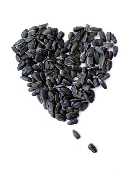 Semillas de girasol negras pequeñas. Semillas en forma de corazón y un mes. Un puñado de semillas
. - Foto, Imagen