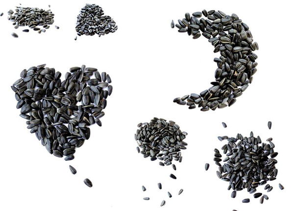 Schwarze kleine Sonnenblumenkerne. Samen in der Form eines Herzens und einen Monat. Eine Handvoll Saatgut. - Foto, Bild