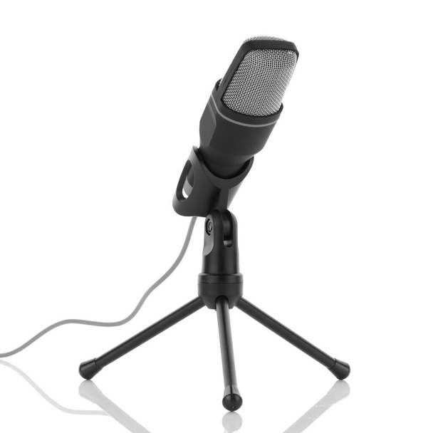 Black and grey microphone on white surface with reflection - Foto, imagen