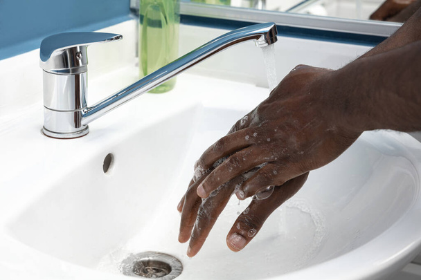 Mann wäscht sich im Badezimmer sorgfältig die Hände aus nächster Nähe. Verhinderung der Ausbreitung von Infektionen und Lungenentzündung - Foto, Bild