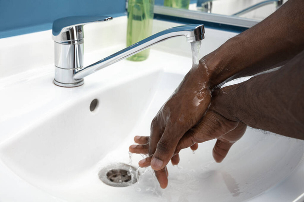 Man washing hands carefully in bathroom close up. Prevention of infection and pneumonia virus spreading - Photo, image