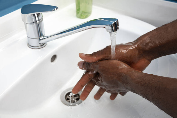 Mężczyzna myje ręce ostrożnie w łazience. Zapobieganie rozprzestrzenianiu się zakażenia i wirusa zapalenia płuc - Zdjęcie, obraz