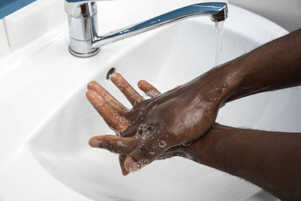 Mann wäscht sich im Badezimmer sorgfältig die Hände aus nächster Nähe. Verhinderung der Ausbreitung von Infektionen und Lungenentzündung - Foto, Bild