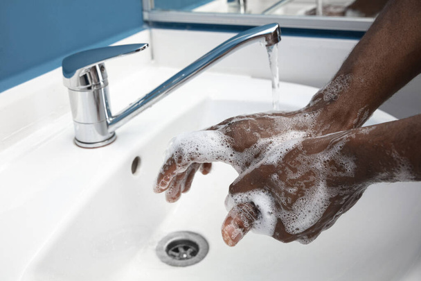 Man washing hands carefully in bathroom close up. Prevention of infection and pneumonia virus spreading - Φωτογραφία, εικόνα