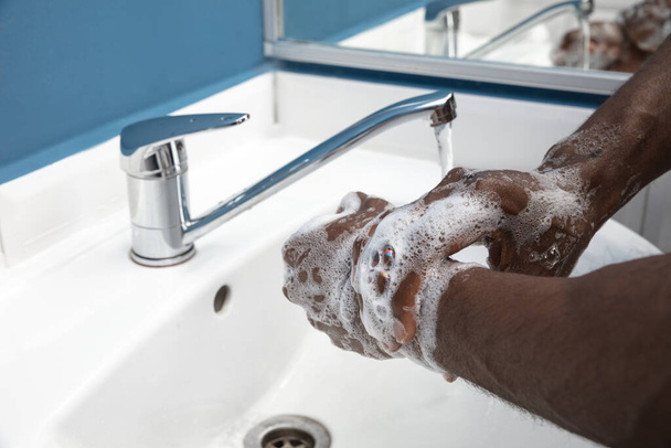 Man washing hands carefully in bathroom close up. Prevention of infection and pneumonia virus spreading - Photo, Image