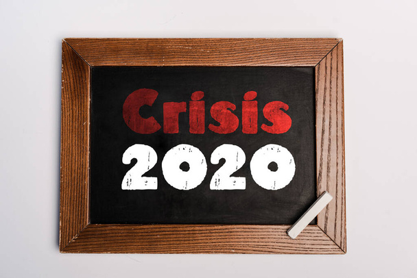 crisis 2020 letras escritas en pizarra sobre fondo blanco, concepto coronavirus
 - Foto, imagen