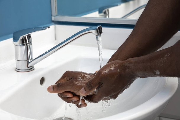 Man washing hands carefully in bathroom close up. Prevention of infection and pneumonia virus spreading - Photo, image
