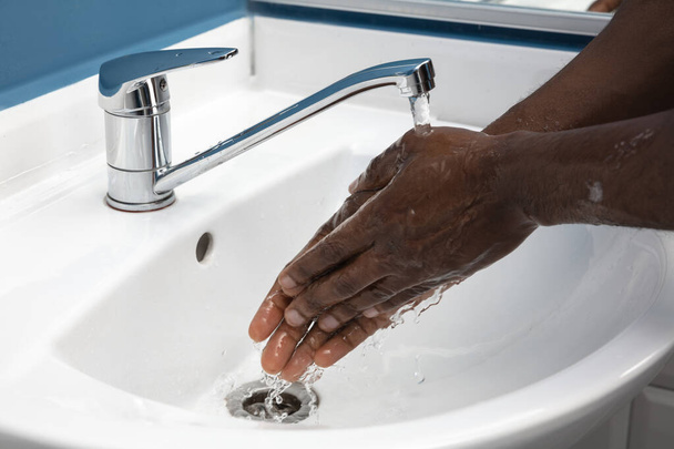 Man washing hands carefully in bathroom close up. Prevention of infection and pneumonia virus spreading - Foto, immagini