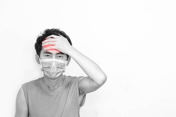 Hombre con máscaras médicas con dolor de cabeza, Emocional foto en blanco y negro con zona de dolor rojo
. - Foto, Imagen