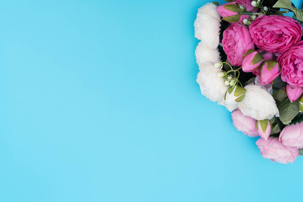Pink and white flowers on blue background. Mother's Day, Spring concept. Greeting, invitation card. Flat lay, top view style with copy space for your text. - 写真・画像