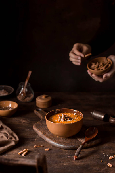 Pumpkin soup with crackers, atmospheric photo with hands. - Zdjęcie, obraz
