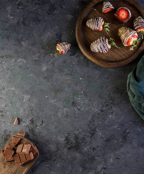 Dark background with strawberries and chocolate. Free space, frame. - Foto, imagen