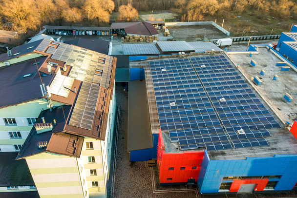 Vista aérea de muchos paneles solares fotovoltaicos montados en el techo de un edificio industrial. - Foto, Imagen