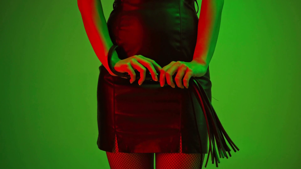 vista recortada de la mujer dominante sosteniendo azotes látigo en verde
  - Imágenes, Vídeo