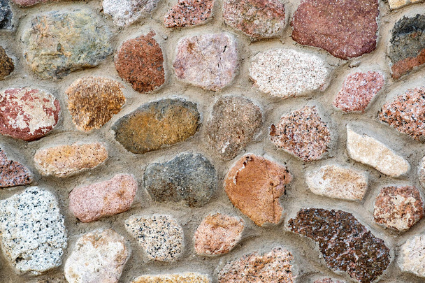 Flache Detailansicht einer Wand aus verschiedenen Steinen. Abstrakter Steinhintergrund. - Foto, Bild