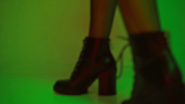rack εστίαση της γυναίκας σε μπότες περπάτημα στο πράσινο  - Πλάνα, βίντεο