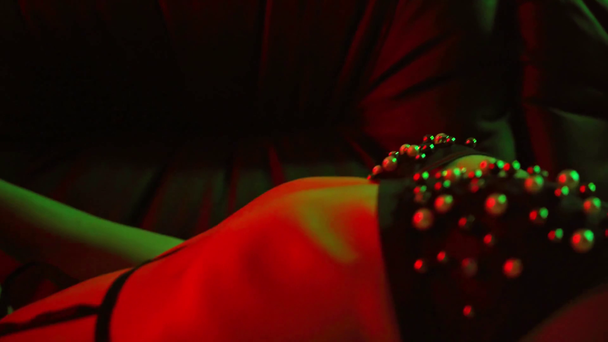 rack ostrości kobiety leżącej na kanapie i dotykając ciała na zielony - Materiał filmowy, wideo