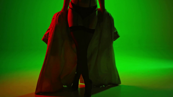 mujer sexy en ropa interior quitándose la gabardina en verde
 - Metraje, vídeo
