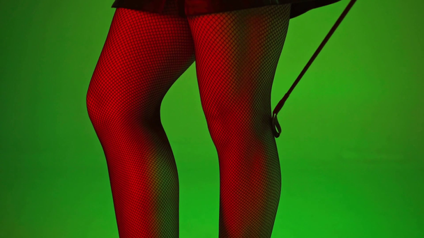 recortado vista de sexy mujer de pie cerca de paleta en verde
  - Imágenes, Vídeo