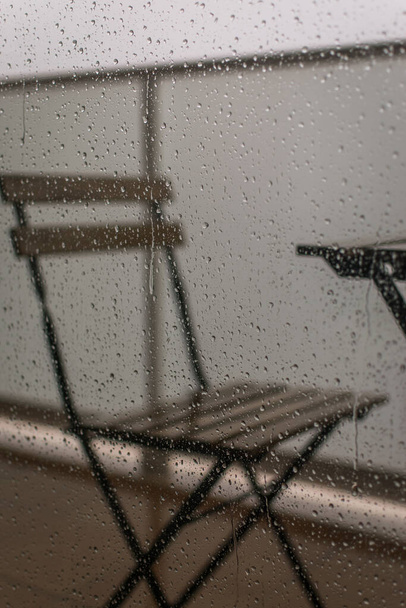 Chair in the rain through a window - Photo, Image