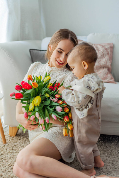 Happy mom and mulatto girl in home interior. Mothers Day. Baby. - 写真・画像
