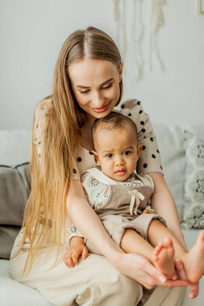Happy mom and mulatto girl in home interior. Mothers Day. Baby. - Foto, Imagem