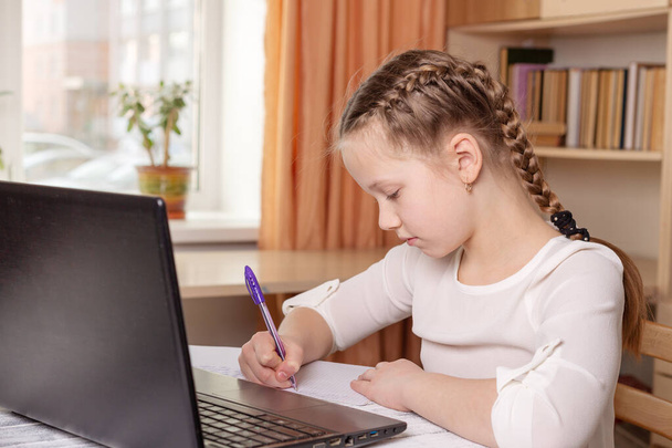 Schoolgirl does homework. Social distance, self-isolation. Home school, online education, home education, quarantine concept - Image - Foto, Imagem