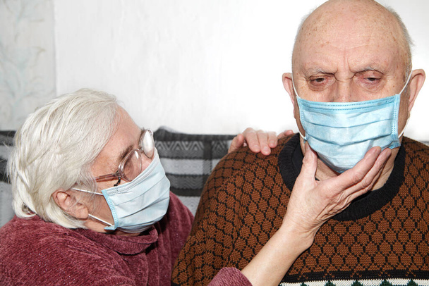 Ζευγάρι ηλικιωμένων με ιατρική μάσκα. Η επιδημία και η βοήθεια - Φωτογραφία, εικόνα