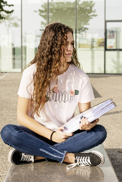 Молода дівчина-підліток в університеті з книгами
 - Фото, зображення