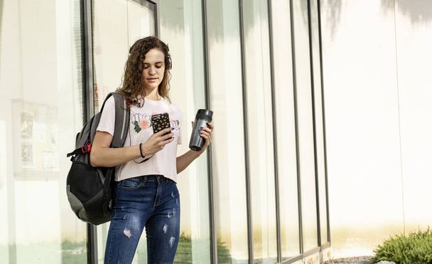 Підлітковий студент У коледжі з мобільною музикою та напоями - Фото, зображення