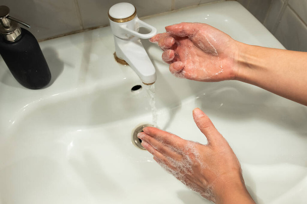 Se laver les mains avec du savon et de l'eau pour prévenir le coronavirus. Le lavage des mains est la pierre angulaire de la lutte contre l'infection. Arrêtez de répandre Covid-19
 - Photo, image