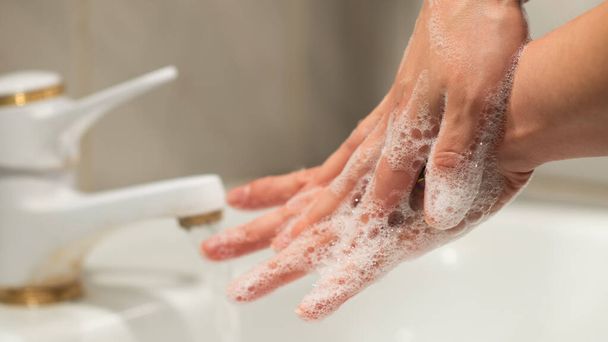 コロナウイルスの予防のために石鹸と水で手を洗う.手洗いは感染管理の礎です。Covid-19の拡散を停止 - 写真・画像