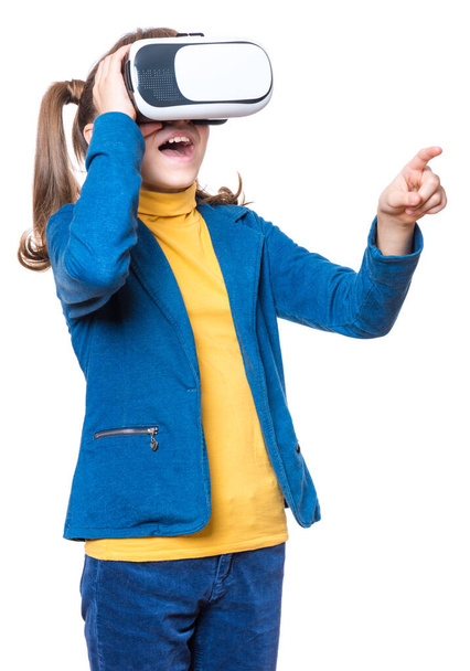 Happy amazed little girl wearing virtual reality goggles watching movies or playing video games, isolated on white background. Cheerful surprised child looking in VR glasses and gesturing - Foto, immagini