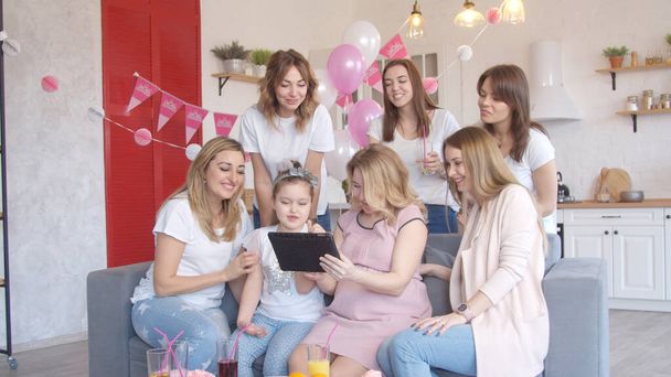 Kobiety patrząc na tabletkę na baby shower party - Zdjęcie, obraz