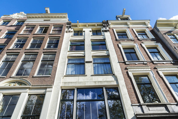 Facade of old traditional leaning houses in Amsterdam, Netherlands - Fotoğraf, Görsel
