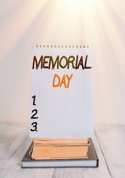 Fogalmi kézírás a Memorial Day-ről. Üzleti fotó szöveg emlékezve a katonai demonstráció, aki meghalt a szolgáltatás Front view stacked könyvek spirál jegyzet könyv vintage fa asztal. - Fotó, kép