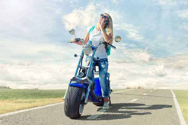 Girl biker sits on a motorcycle. Relax after the trip. - Foto, Imagen