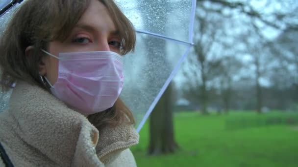 Mulher caucasiana usa máscara protetora enquanto em um parque público
 - Filmagem, Vídeo