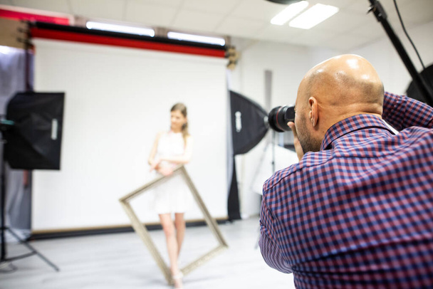 Fotógrafo profesional tomando fotos con una modelo femenina en estudio profesional, concepto de fotografía
 - Foto, imagen