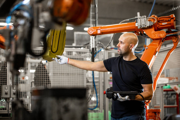 Inženýr opravy automatických robotů v automobilovém průmyslu, chytrá továrna, průmyslový koncept - Fotografie, Obrázek