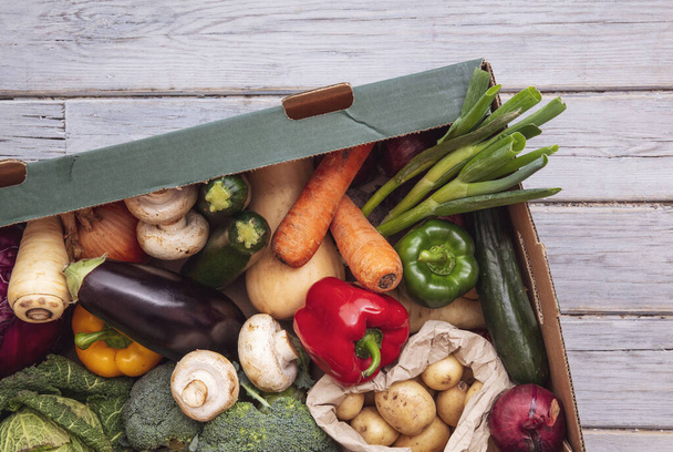Fresh organic vegetable delivery box on a wooden background - Foto, Imagem